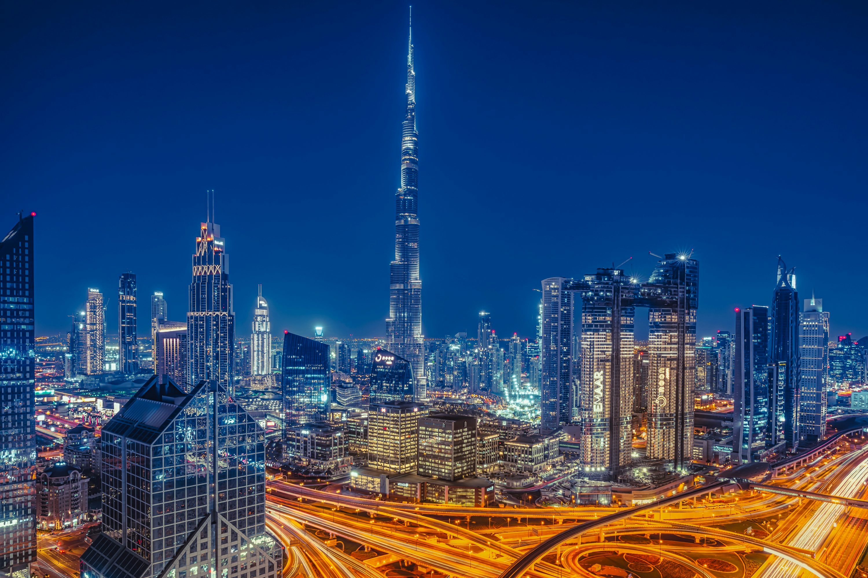 Horizonte iluminado de Dubai à noite, Emirados Árabes Unidos.