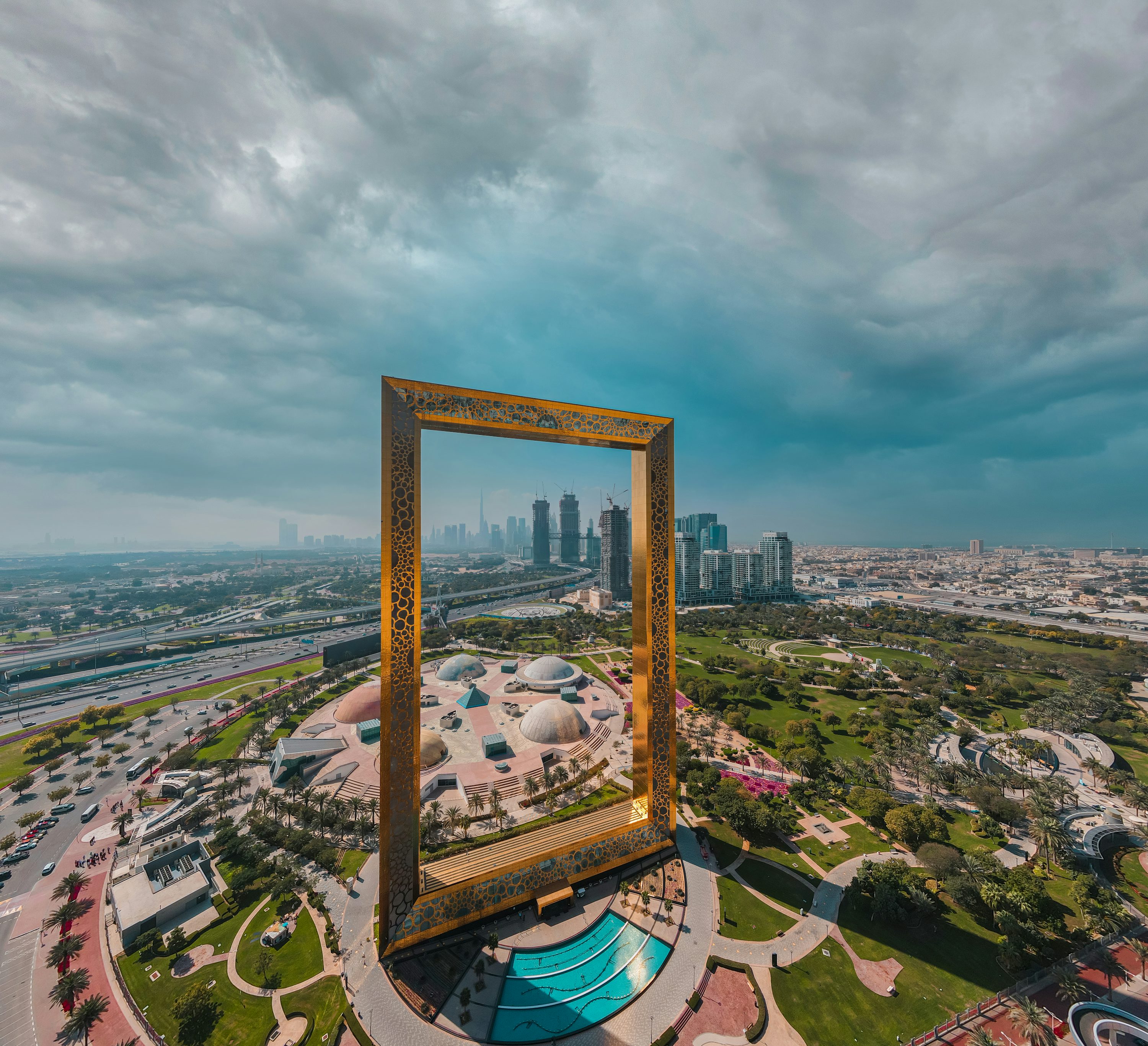 Dubai Frame visto de uma área urbana com parques e céu nublado.