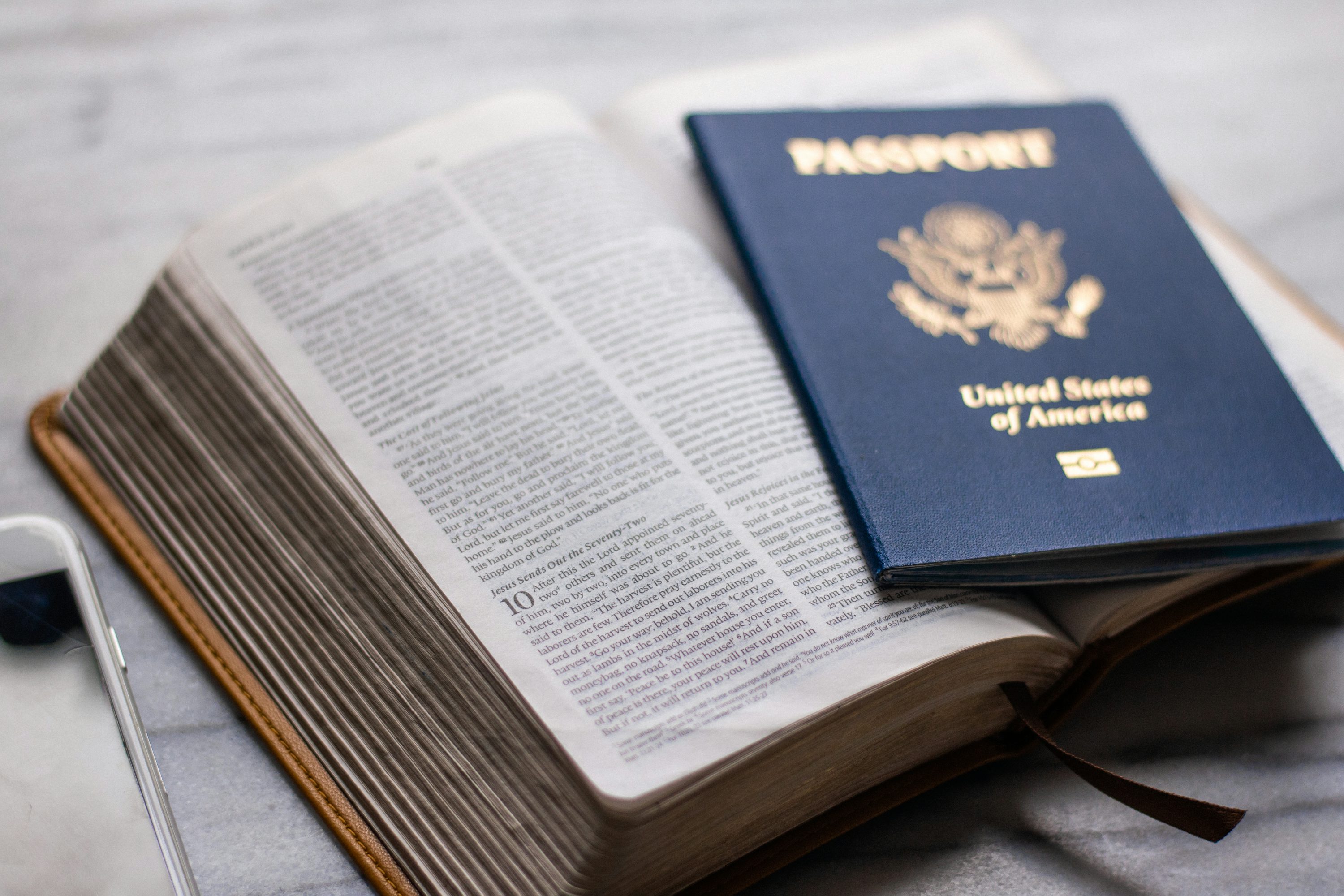 Passaporte apoiado sobre páginas abertas de um livro.