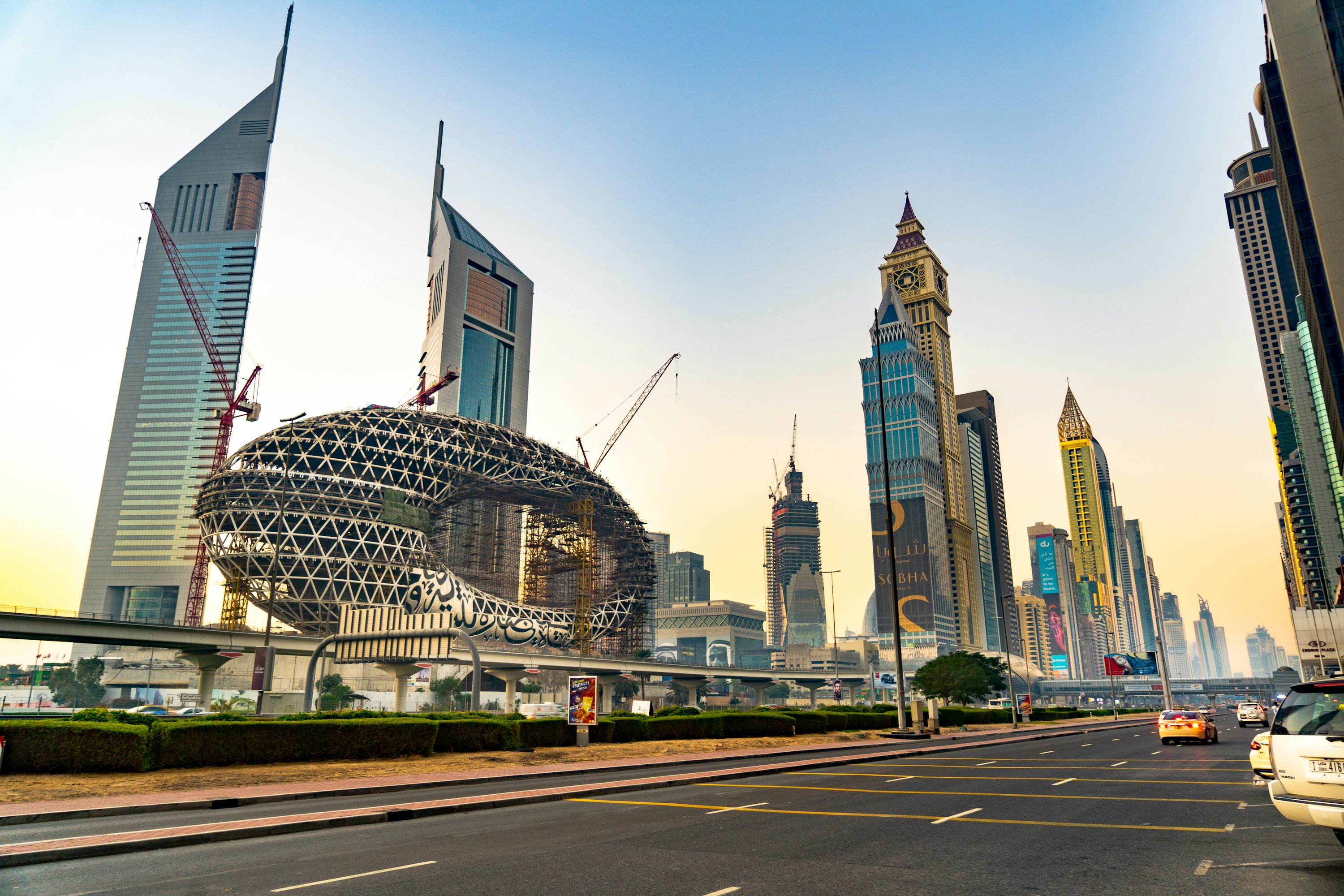 Vista de Dubai com edifícios modernos, palmeiras e céu azul.