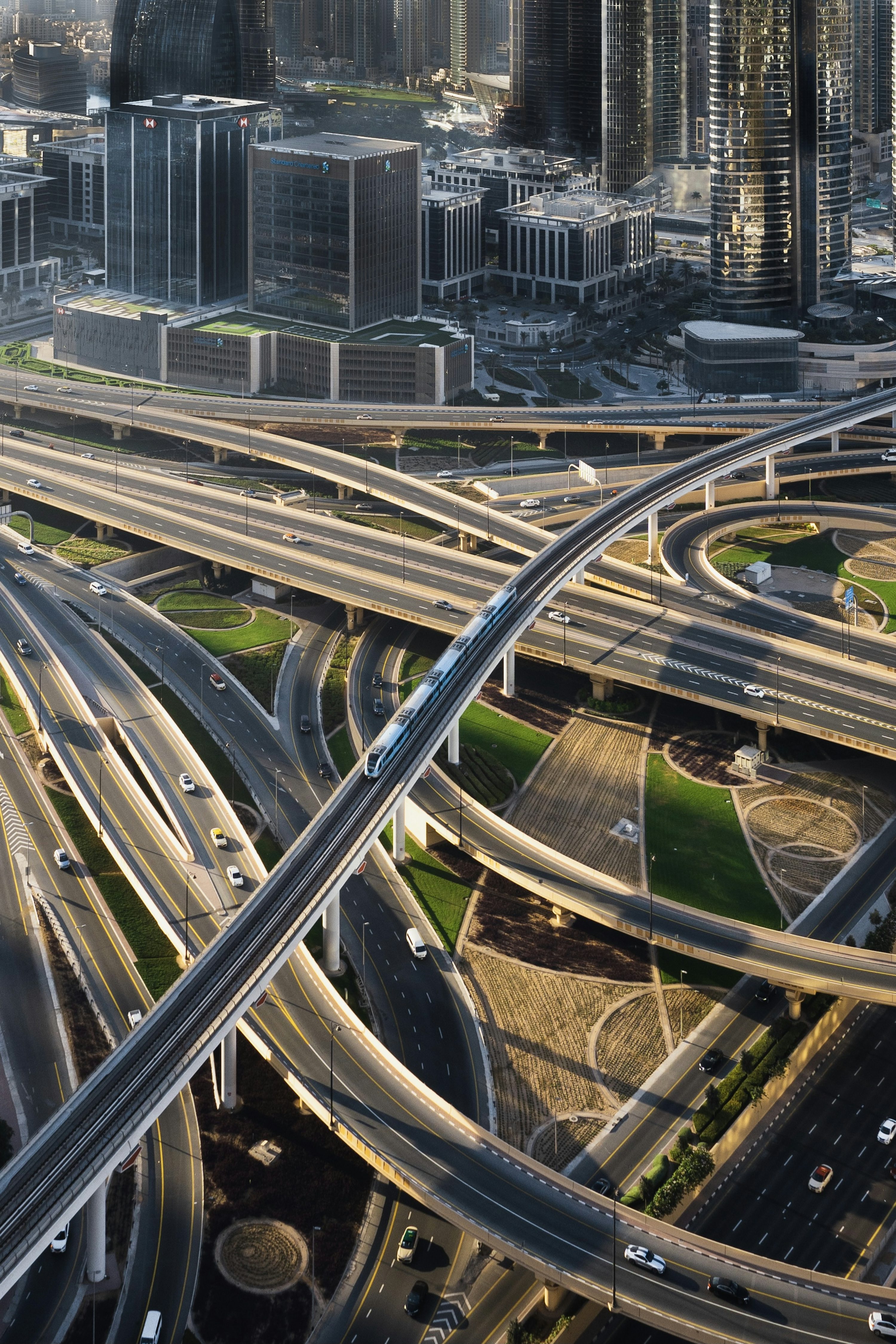 Vista aérea de vias elevadas e edifícios de Dubai ao entardecer.