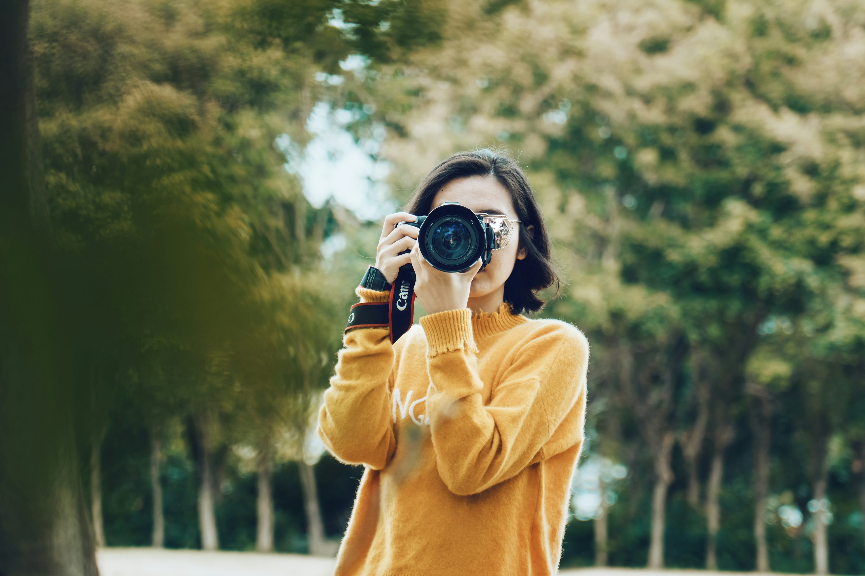 Pessoa usando uma câmera para fazer fotografia em ambiente externo.