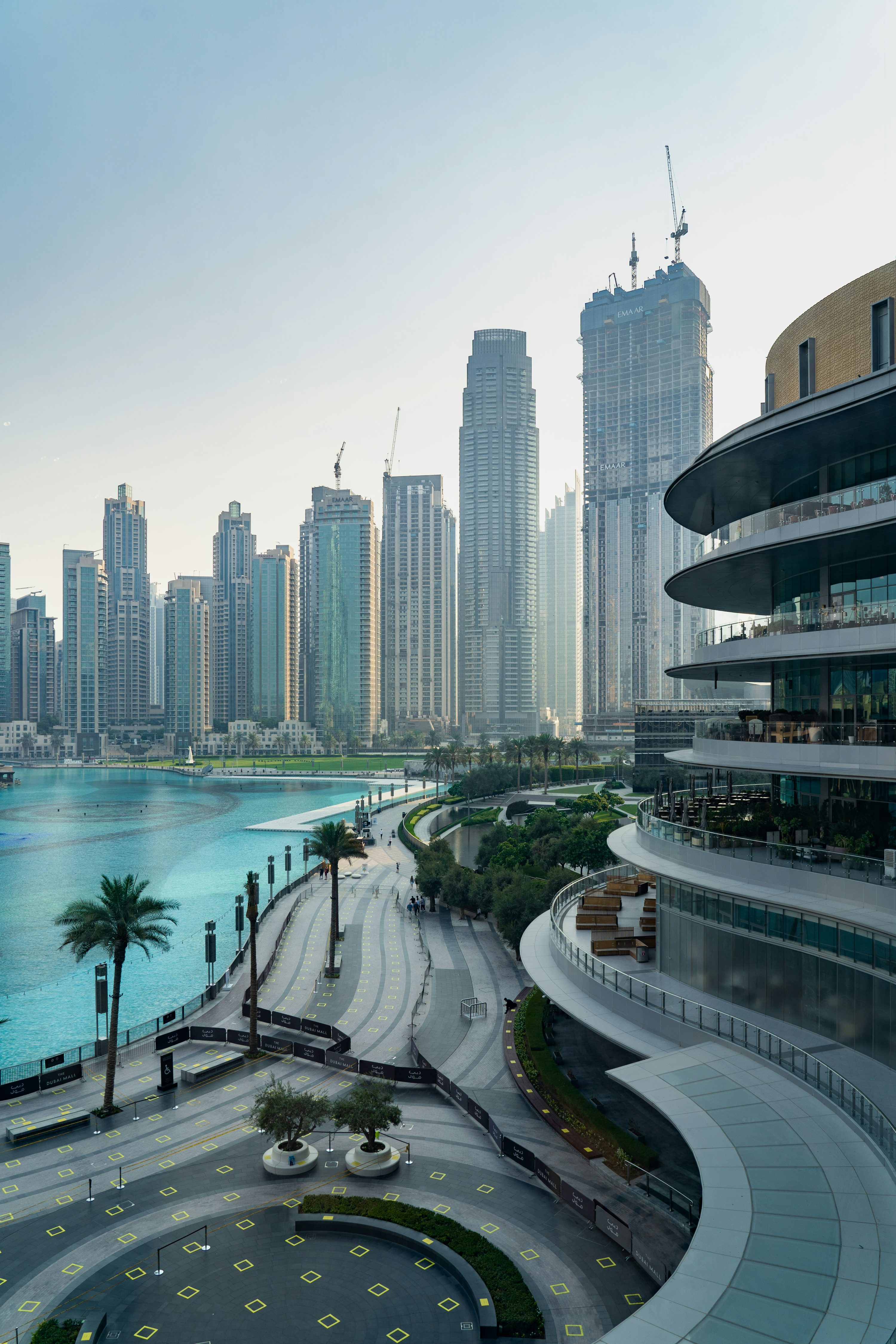 Vista urbana de Dubai com torres e água em primeiro plano.