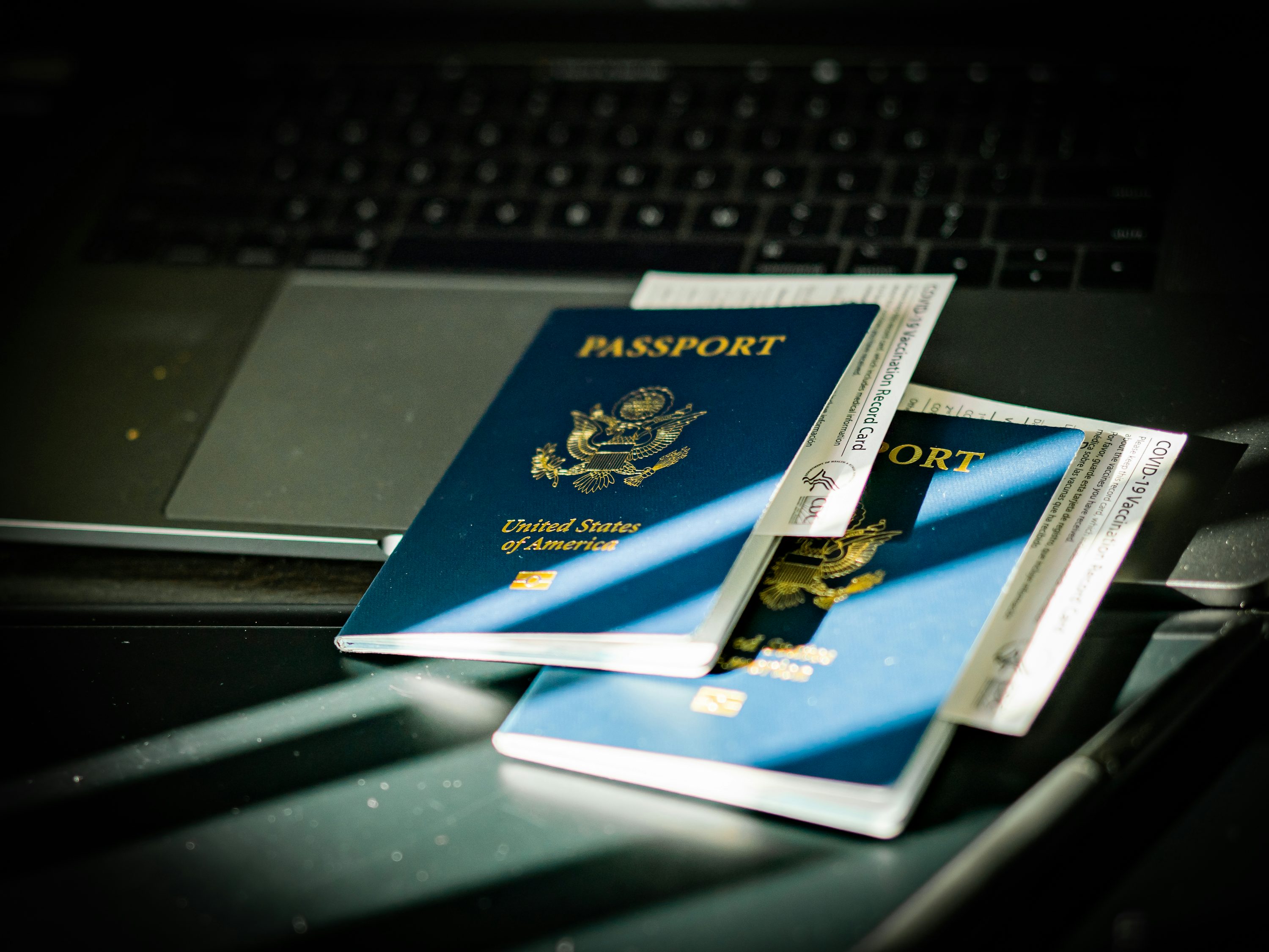 Passaporte e documentos sobre um computador.