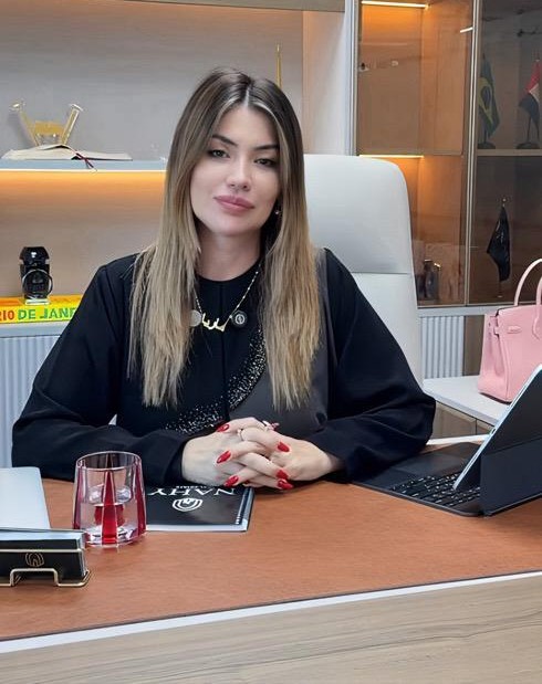 Mariane Nunes, empresária brasileira em Dubai, sentada em escritório