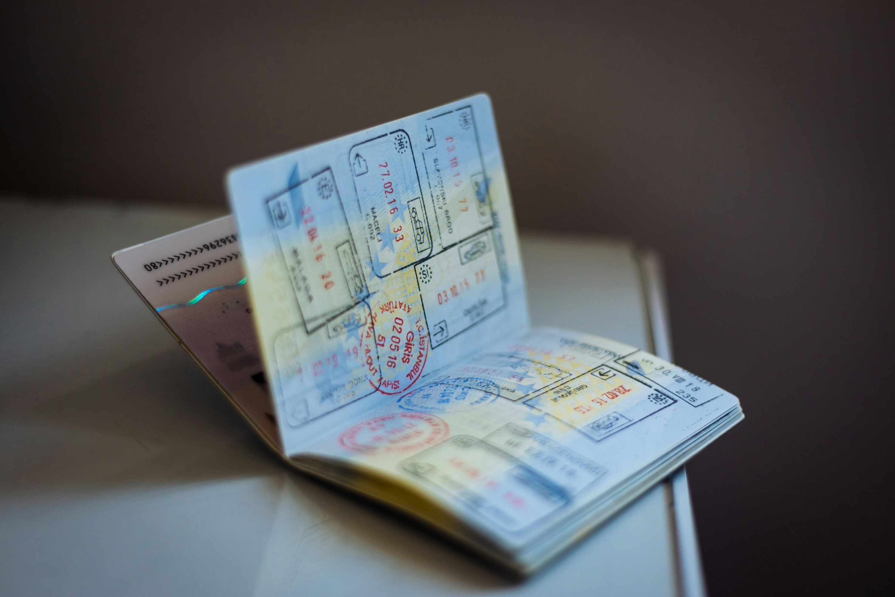 Passaporte e documentos de viagem apoiados sobre uma superfície clara.
