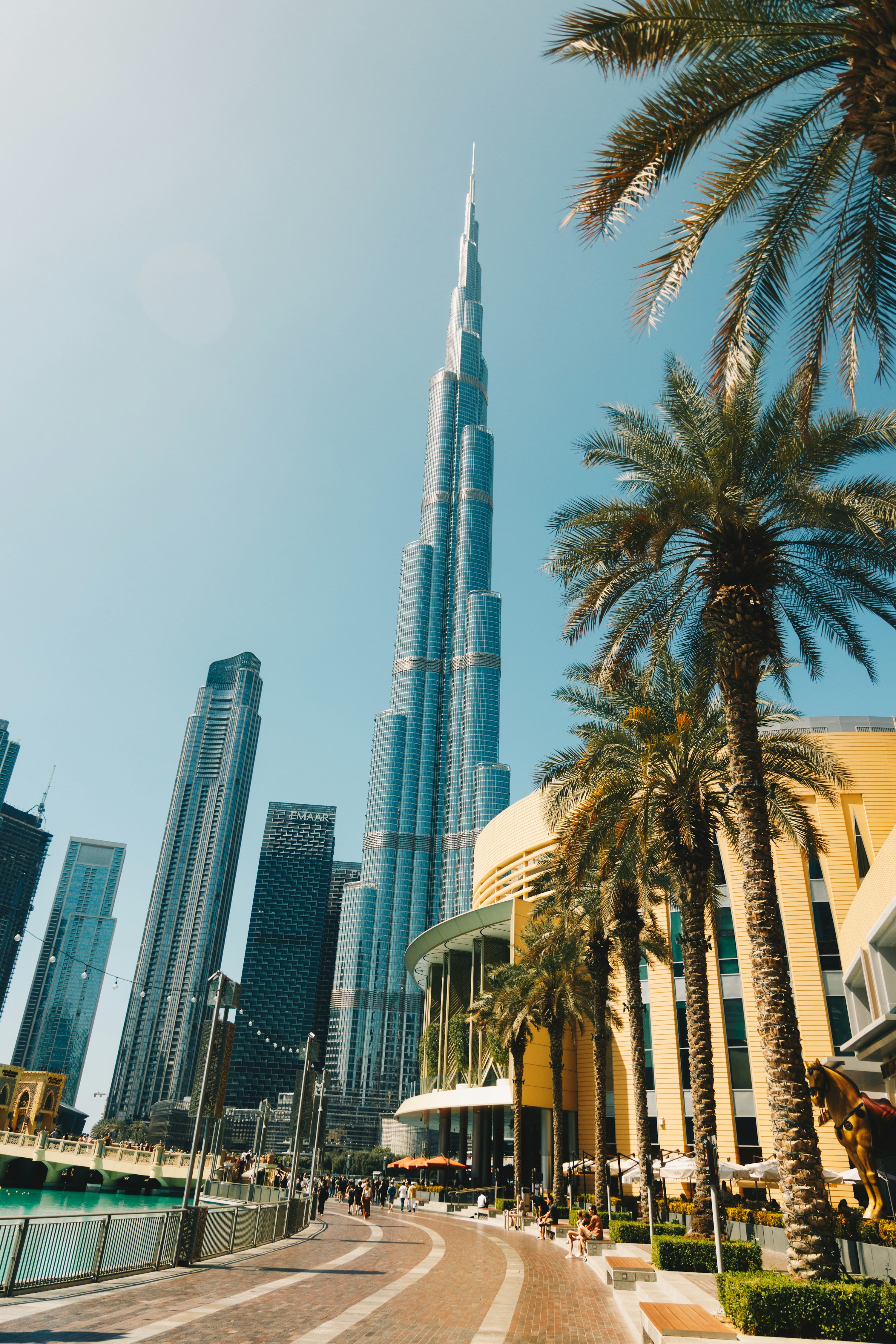 Burj Khalifa entre palmeiras e edifícios modernos em Dubai.