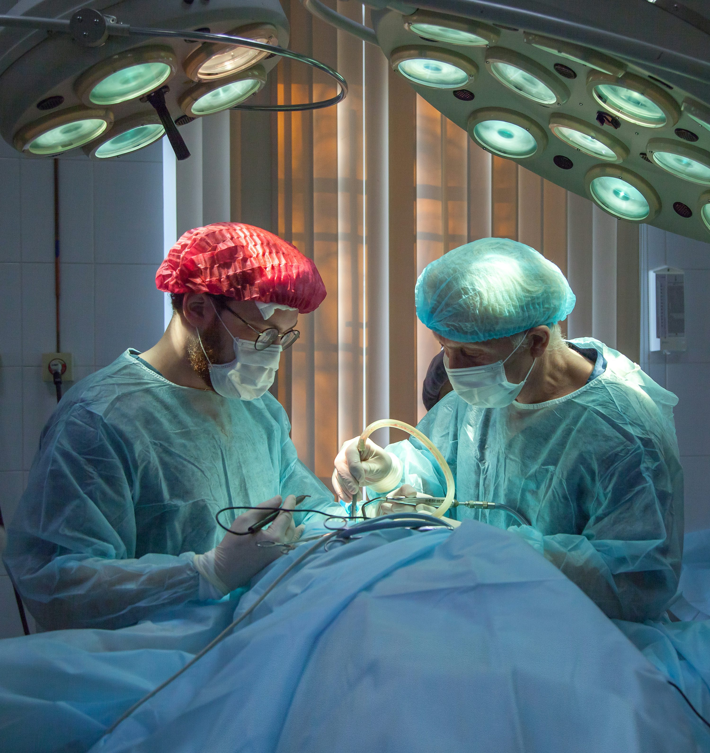 Equipe médica em centro cirúrgico iluminado.