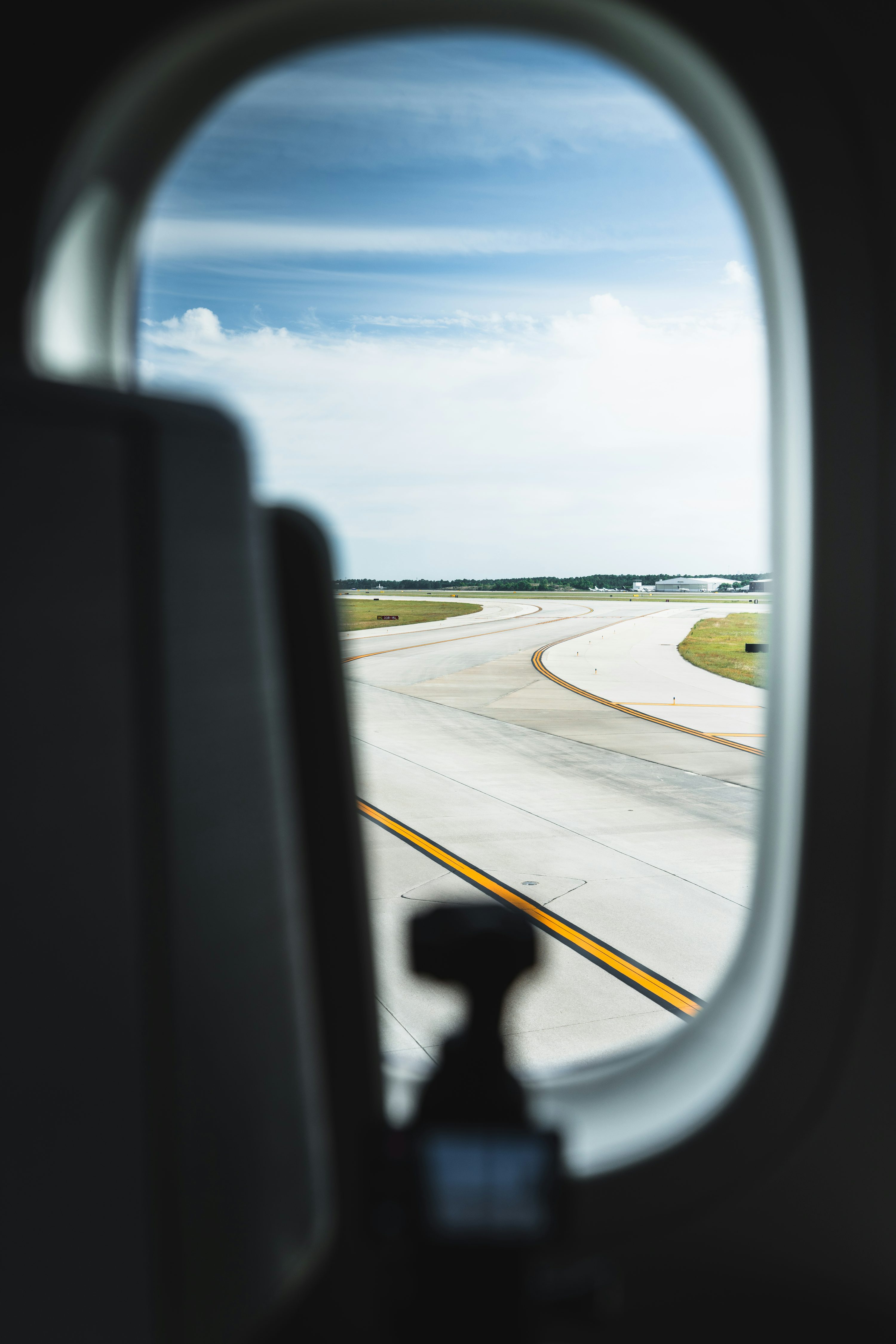 Vista da pista de aeroporto através da janela de uma aeronave.